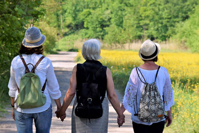 Three patients walking together through a field during outdoor therapy at a drug and alcohol rehab clinic in Glasgow