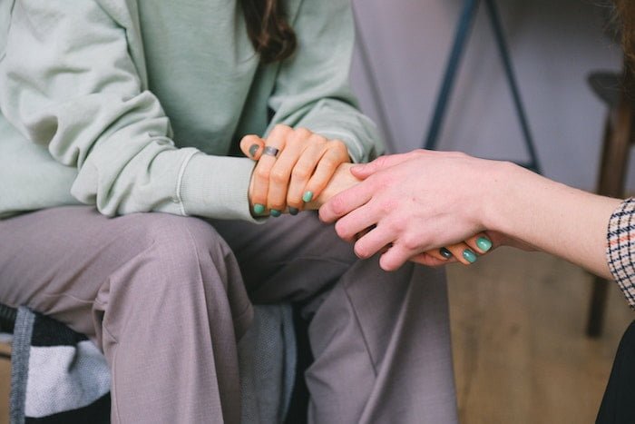 Two people holding hands at a drug and alcohol rehab in Glasgow