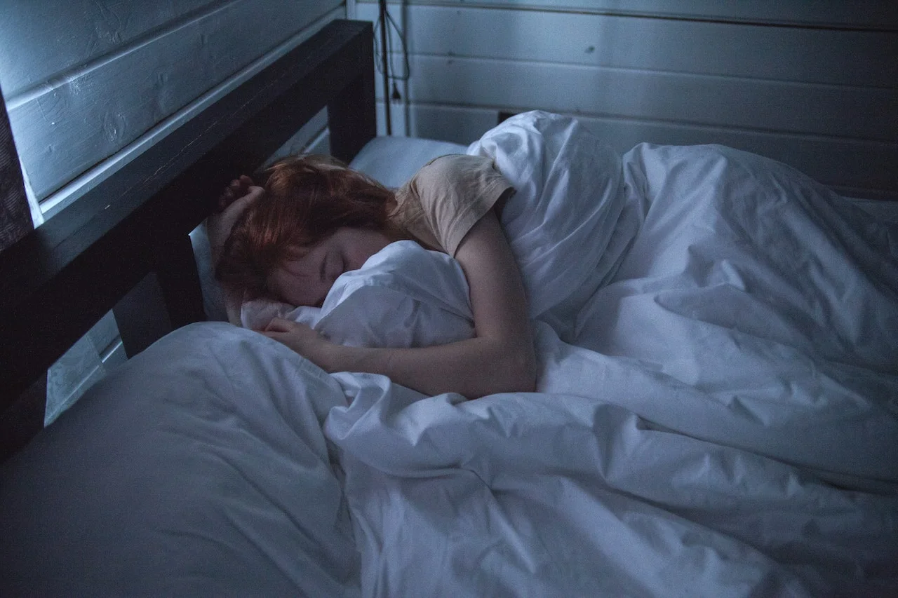 A woman sleeping in a dimly lit room