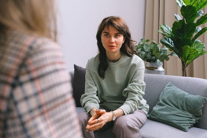 Patient sat on a sofa speaking with an addiction counsellor