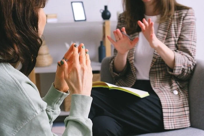 Two people taking notes and discussing eating disorders